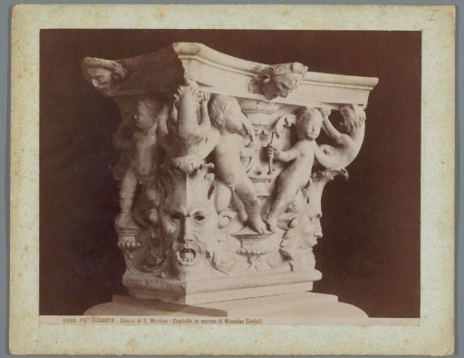 Capital with mask heads and putti in the cathedral of Pietrasanta