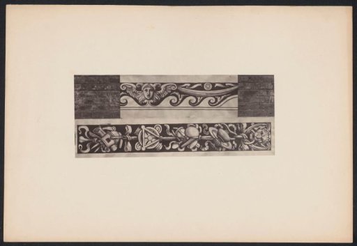 Two ornamental prints with a winged female head and a lion head on a wall