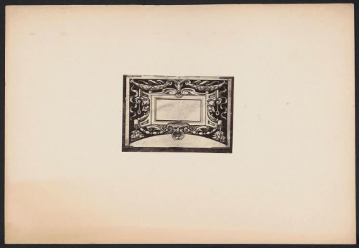 Ornamental print with a mask and a ram's head on a wall