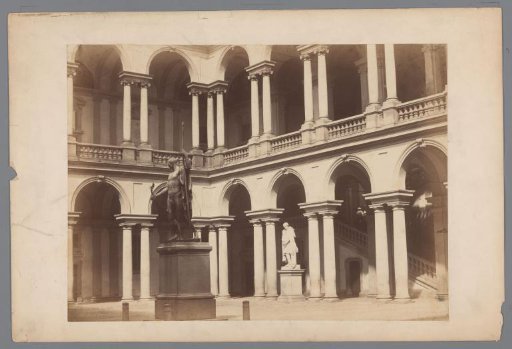 Courtyard with two statues of a building with two colonnaded galleries on two floors