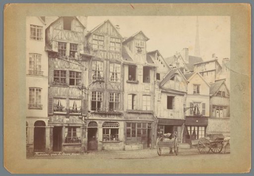 Street scene in Rouen with half-timbered houses and two horse-drawn carts
