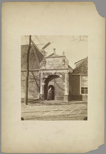 Gate of the Sint Anthonygasthuis in Groningen with a woman in the doorway