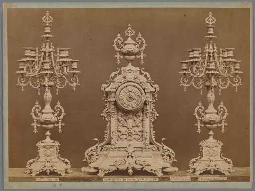 Table clock with two candlesticks, decorated with lionesses