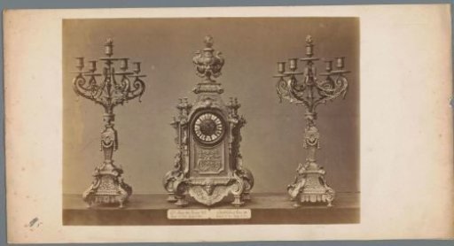 Table clock with two candlesticks, decorated with lion heads