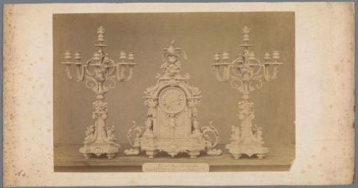 Table clock with two candlesticks, decorated with a bird