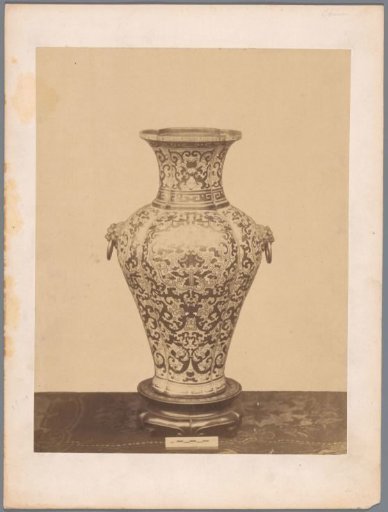 Vase decorated with an organic motif, flanked by two lion heads holding a ring in their mouths