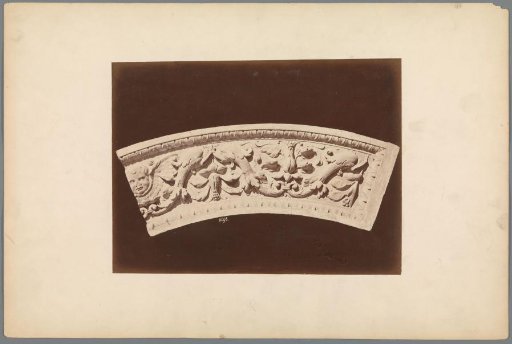Semi-circular relief with plant motifs and a putto