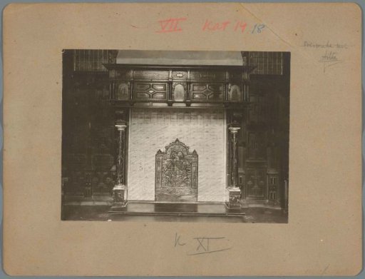 Fireplace with a grate decorated with a coat of arms and angels