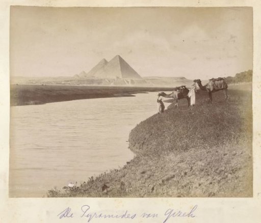 Small caravan at the banks of the Nile with the pyramids of Giza on the opposite side