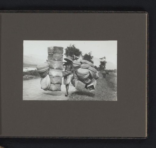 Man carrying baskets with a carrying pole