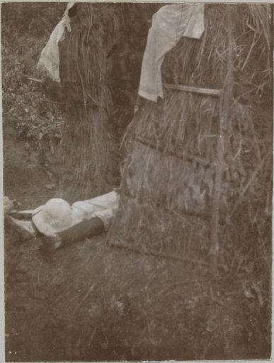 Person lying in a hut (?) on the Idjen Plateau, East Java, Dutch East Indies