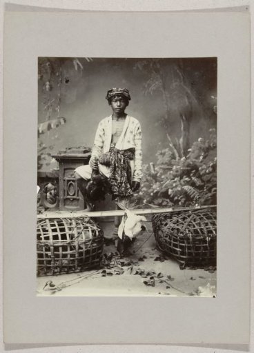 Studio portrait of a boy with chickens in the Dutch East Indies