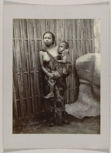 Studio portrait of a woman with a child on her hip in the Dutch East Indies