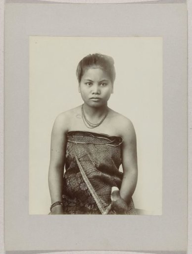 Studio portrait of a woman with a bird in the Dutch East Indies