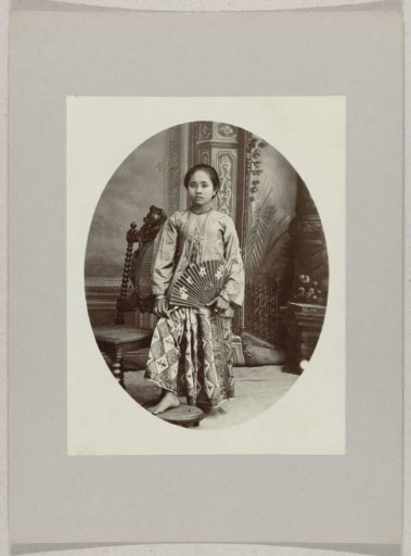 Studio portrait of a girl with a fan in the Dutch East Indies