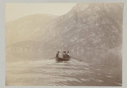 Rowing boat with five people, on the way to the shore