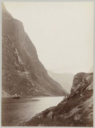 Ship on a river in the mountainous Norwegian landscape