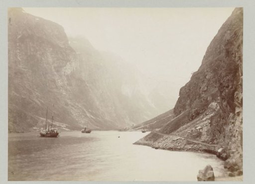 Ship on a river in the mountainous Norwegian landscape
