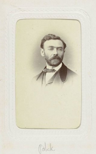 Studio portrait of a man with a mustache and beard in a jacket with a velvet collar