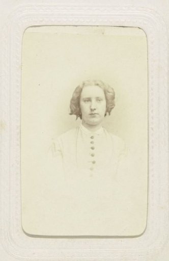Studio portrait of a woman in a high-closed dress and ringlets in her hair