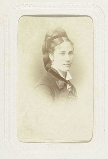 Studio portrait of a woman with braided hair and a medal or decoration around her neck