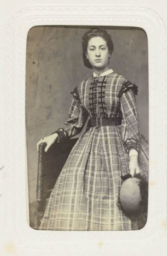 Studio portrait of a young woman in a long plaid dress