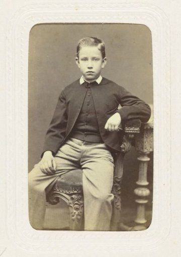 Studio portrait of a boy on a chair