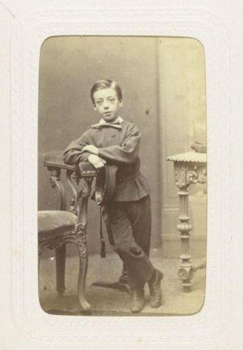 Studio portrait of a boy in a suit with a large bow