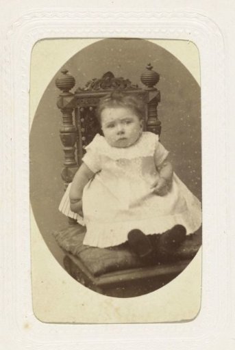 Studio portrait of a baby in a white dress