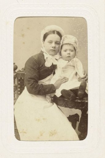 Studio portrait of a woman with a baby, both wearing white caps