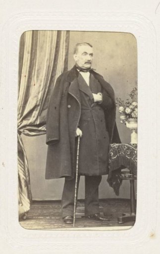 Studio portrait of an older man in a costume with an overcoat