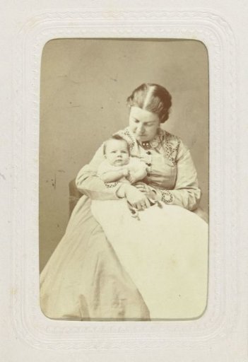 Studio portrait of a woman with a baby in a white dress on her lap