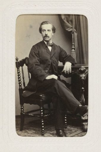 Studio Portrait of a Man with Mustache Sitting on a Chair