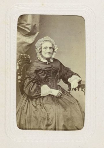Studio portrait of an older lady dressed in a black puff-sleeve dress