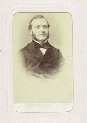 Studio portrait of a man with sideburns and a large bow