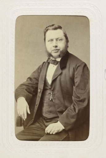 Studio portrait of a man seated on a chair
