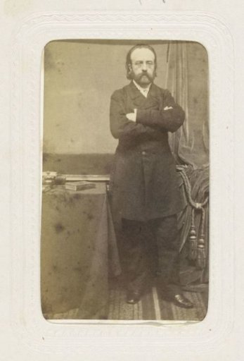 Portrait of a standing man beside a table
