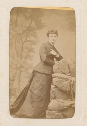 Studio portrait of a young lady before a landscape painting