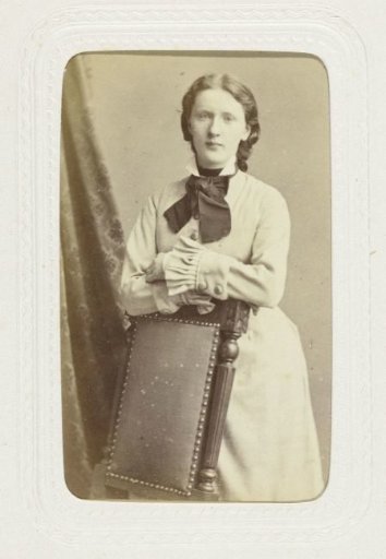 Studio portrait of a woman next to a chair back