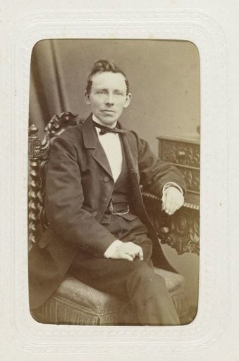 Studio portrait of a man seated at a desk