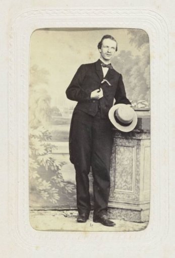 Studio portrait of a man leaning against a pillar