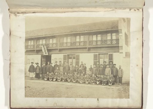 Group photograph of Chinese and European men in front of a building