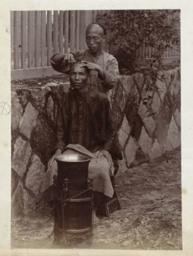 Chinese barber shaving a client on the street