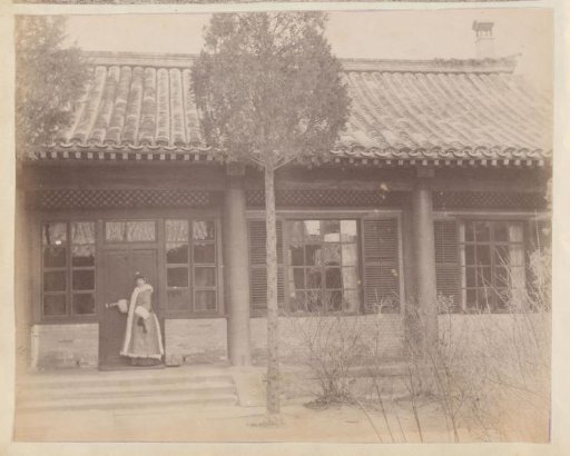 Woman in a winter coat at the door of a Chinese house