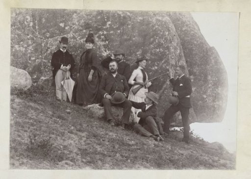 Group portrait of people by a rock