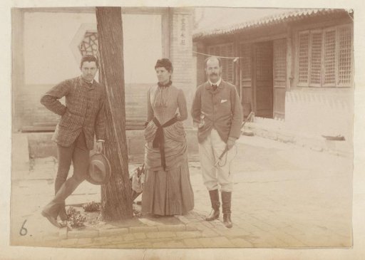 Group portrait of two men and a woman by a tree