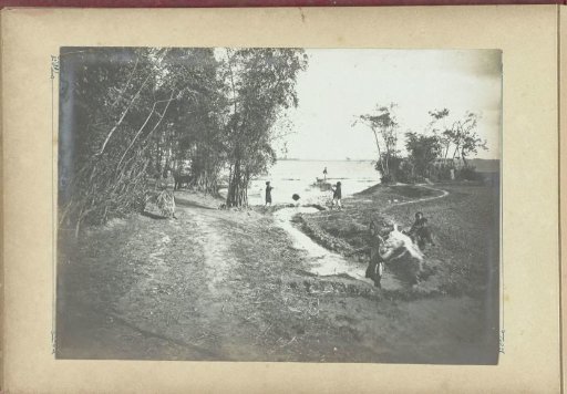 People along the bank of a river, French Indochina