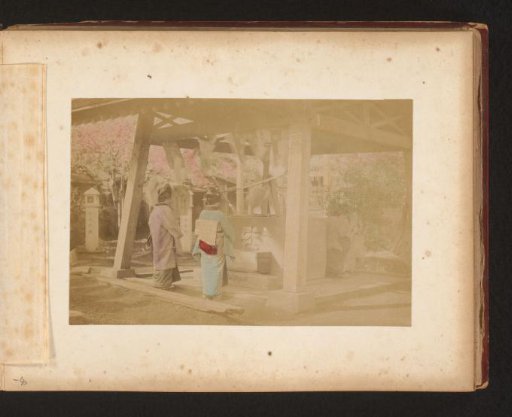 Two Japanese women standing under an awning, possibly at an altar