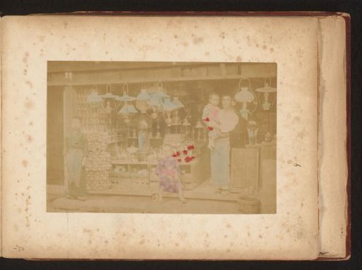 Shopkeeper with three children in front of his shop