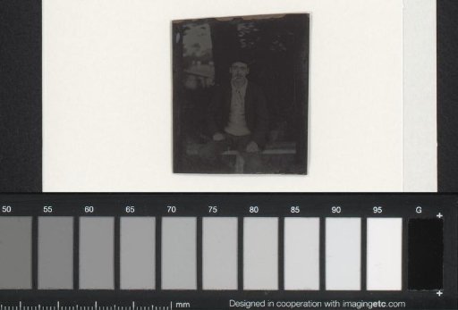 Portrait of a man smoking a cigarette outside on a bench